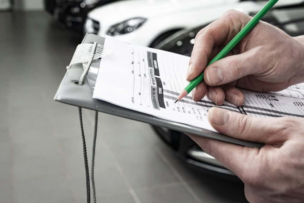 Mechanic writing to the clipboard at workshop warehouse