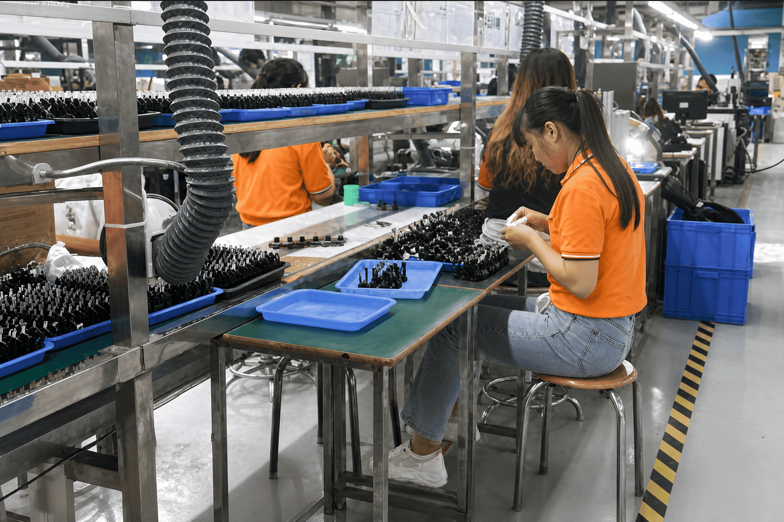 Technicians working on HDMI fiber optic cable assembly in workshop